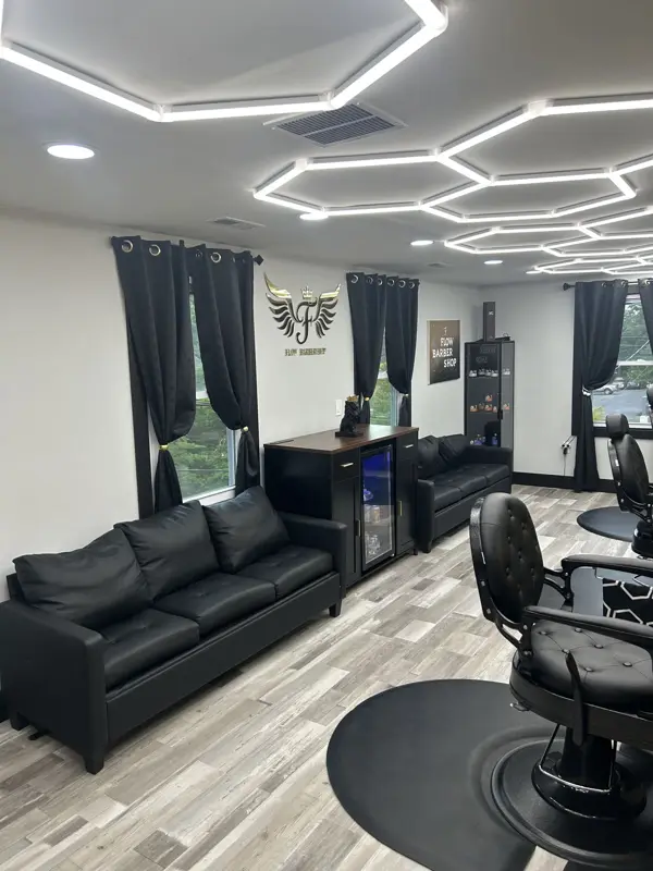 Black leather sofas in the lounge under hexagon LED ceiling lights