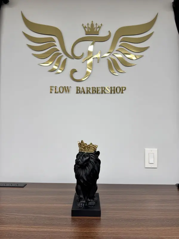 Black lion statue wearing a gold crown beneath the gold Flow logo